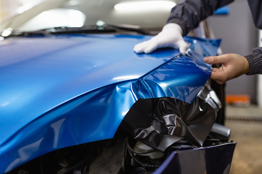 Car bonnet being wrapped in blue vinyl
